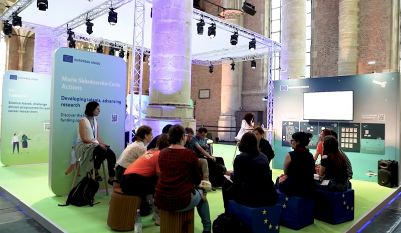 Photo of a small group gathered together on a platform for a discussion.