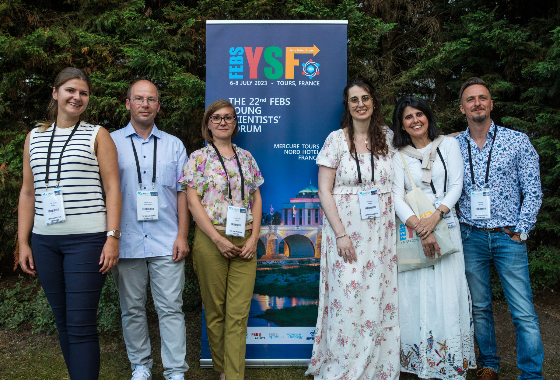 Group photo around an event banner.