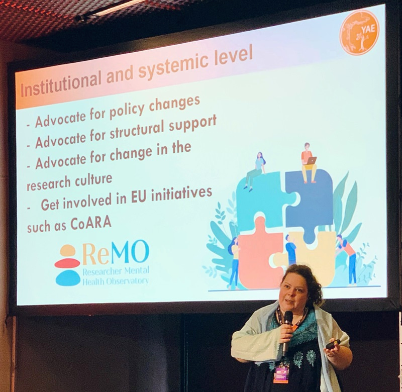 Photo of Katalin Solymosi presenting in front of slide.