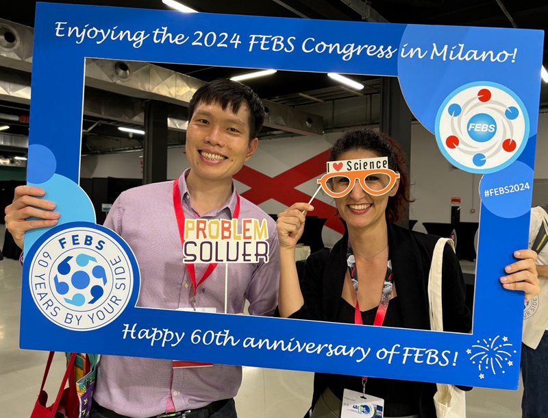 Fun Man and another Congress attendee having their photograph taken while holding a FEBS-branded photo frame.