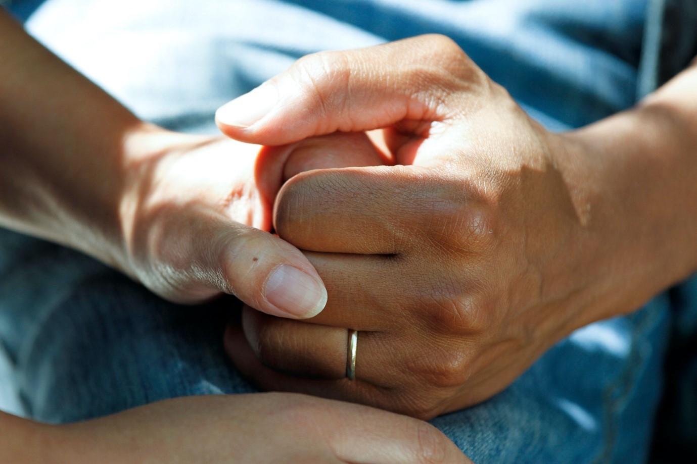 The hand of a nurse holding a patients hand