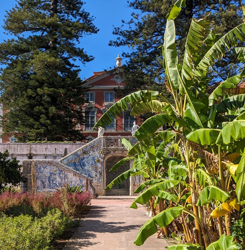 Photo of a building in the background with vegetation and a path in the foreground.