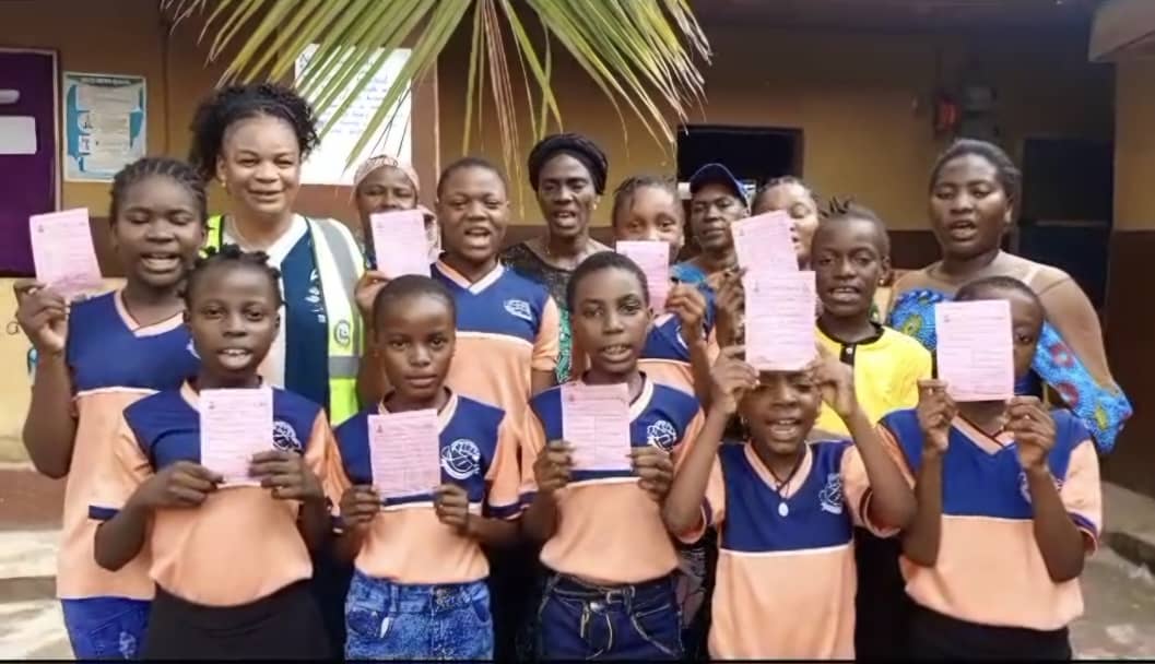 Girls showing their vaccination cards after being vaccinated