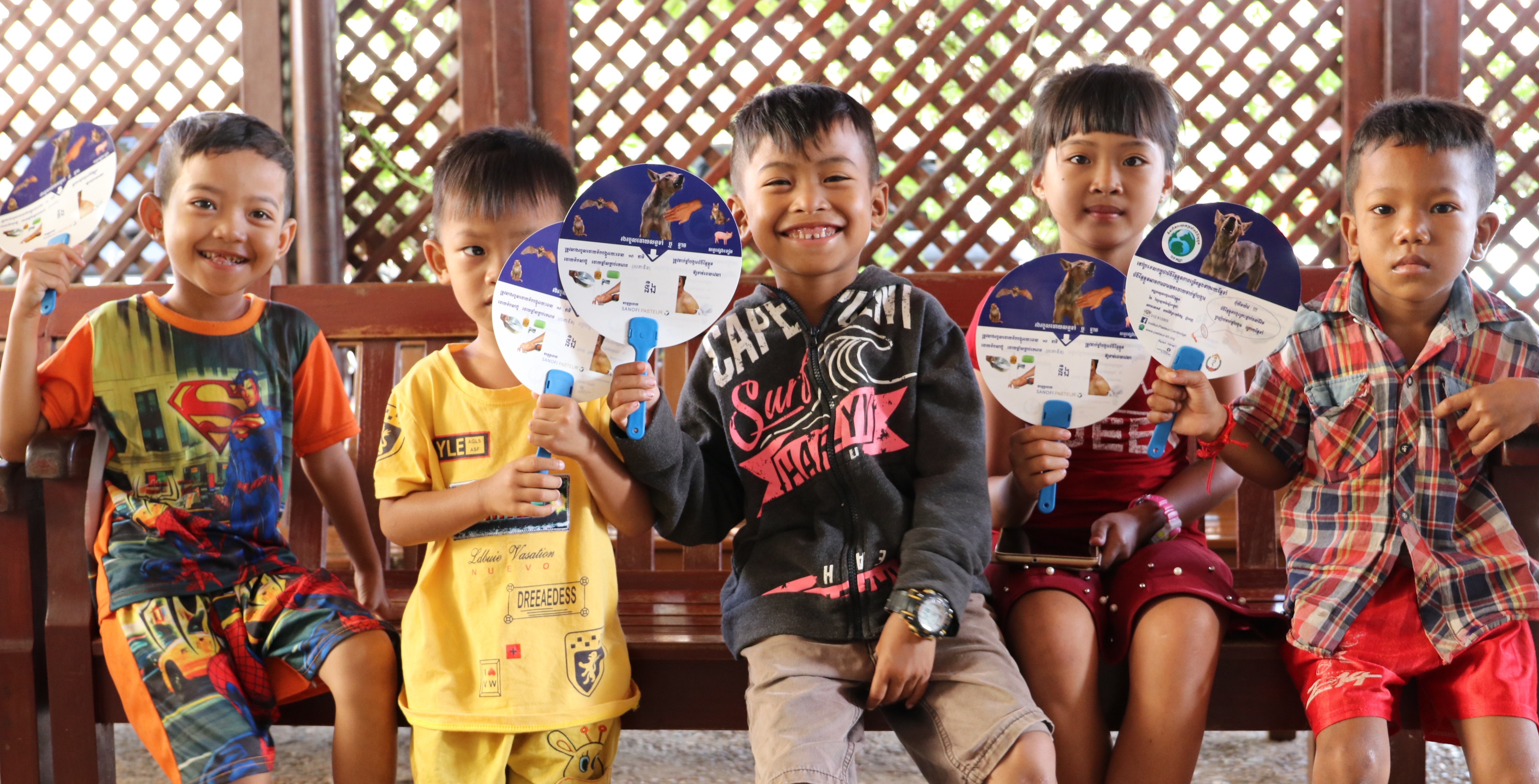 Children at the PEP center of the Institut Pasteur du Cambodge with rabies education material