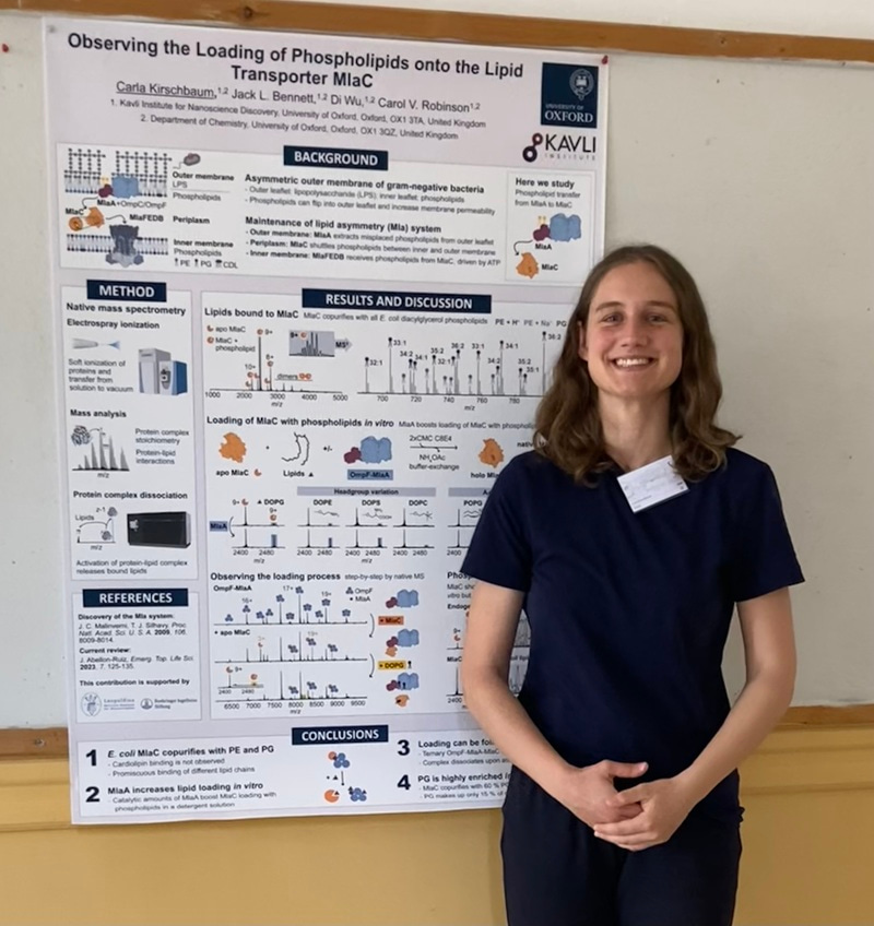 Carla Kirschbaum standing in front a research poster, smiling at the camera.